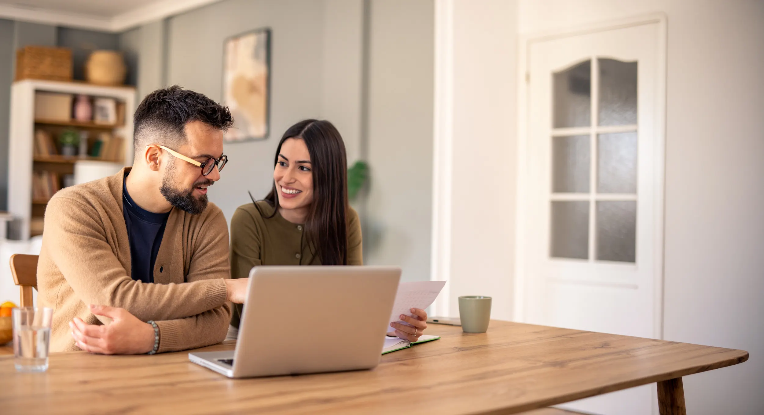 happy couple sitting at a desk discussing finances