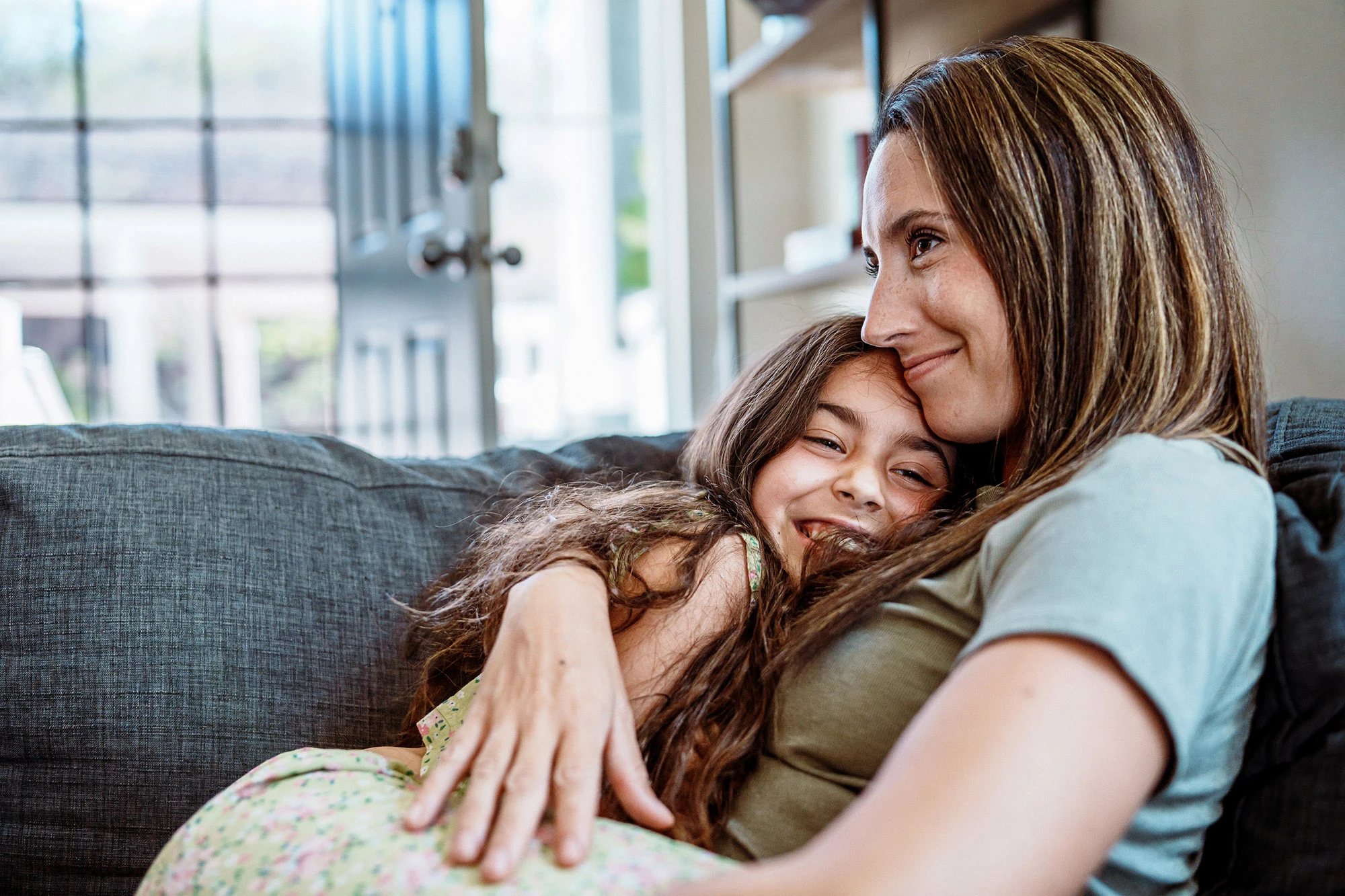 Mother and daughter smiling on the couch