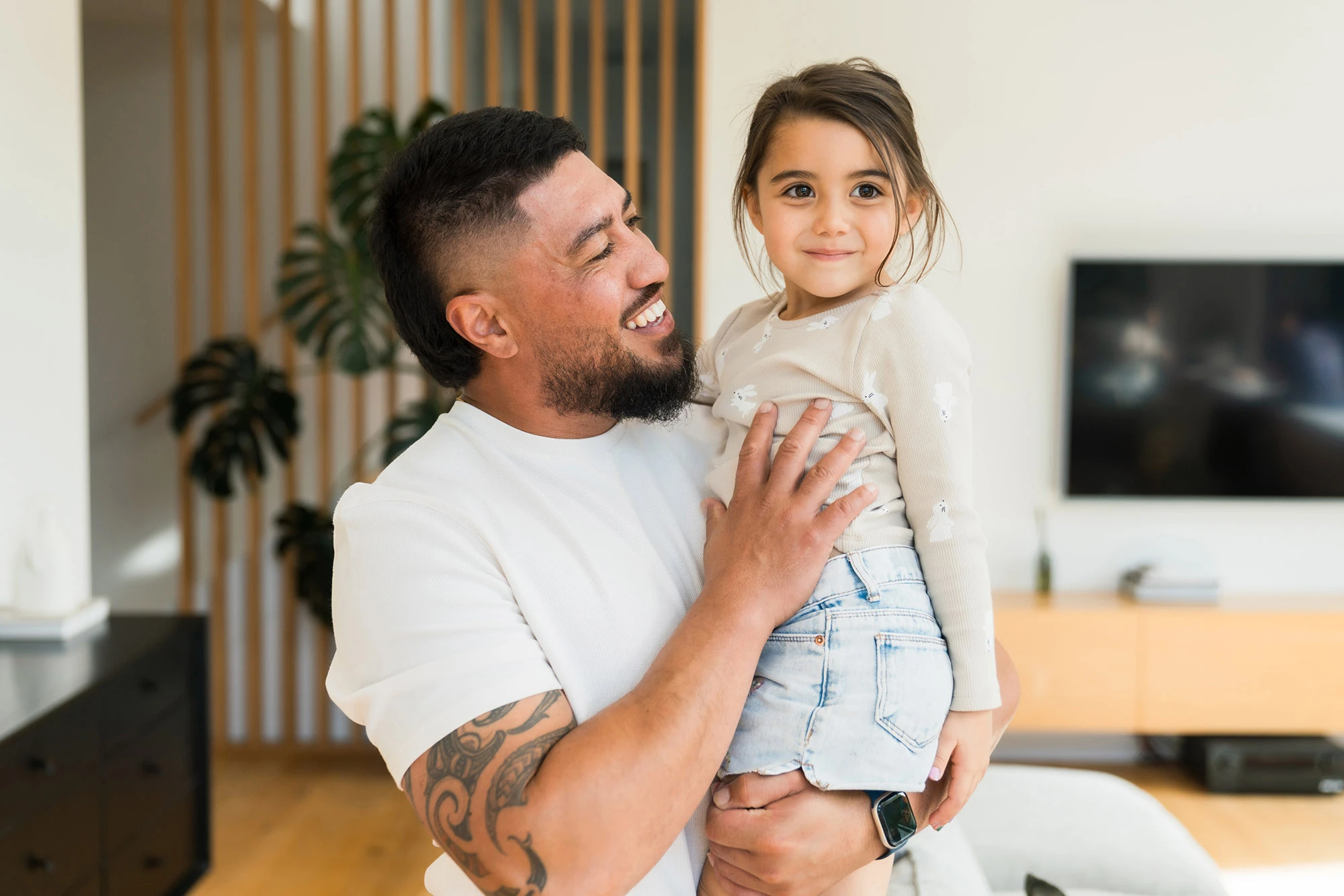 Father holding daughter both smiling at the camera